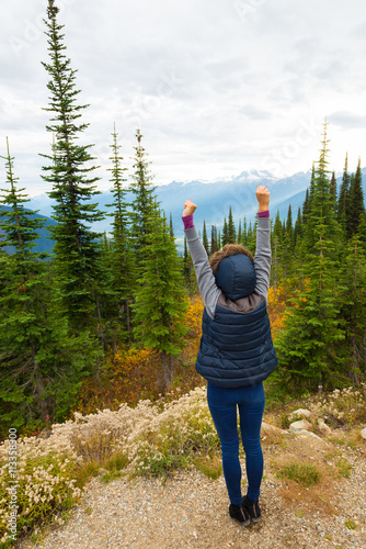 Girl with hands in the air in a mountanous scenery