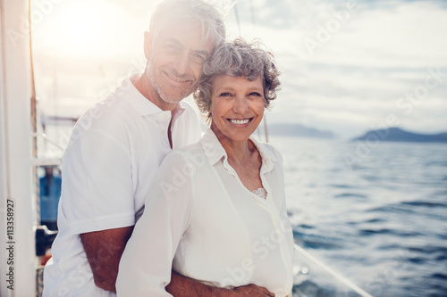 Loving mature couple standing on boat photo