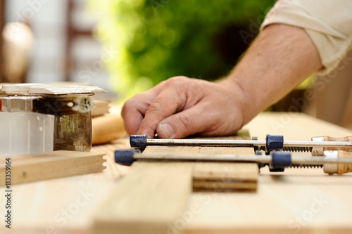 Carpenter hands at work with clamp