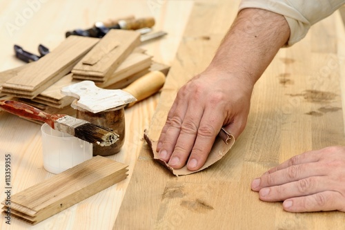 Carpenter hands at work polishing wood