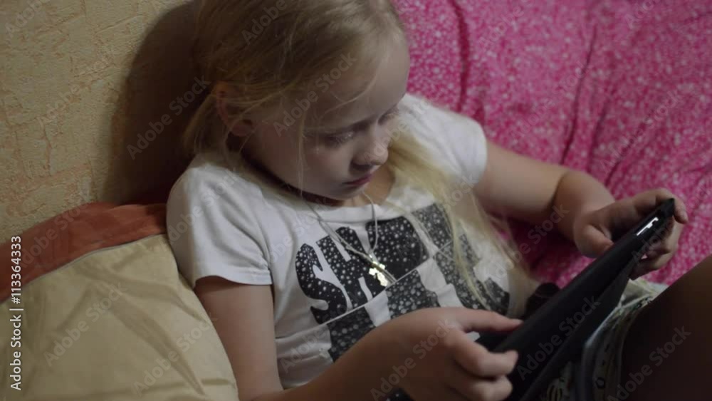 Girl Lying on the Couch and Playing Tablet Girl Lying on the Couch and Playing Tablet