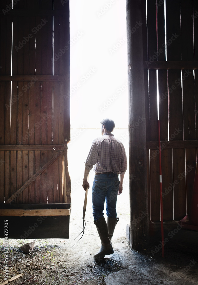 Man standing in doors of barn