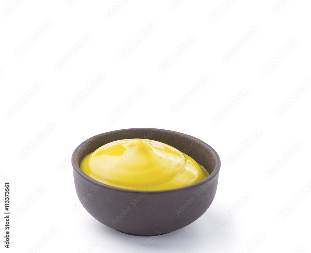 Mustard in brown bowl isolated on white background. Closeup. Mustard in brown bowl isolated on white background. Closeup.