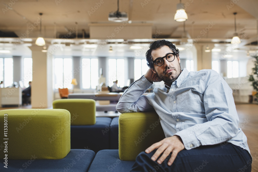 Portrait of mature man sitting on couch at corridor Portrait of mature man sitting on couch at corridor