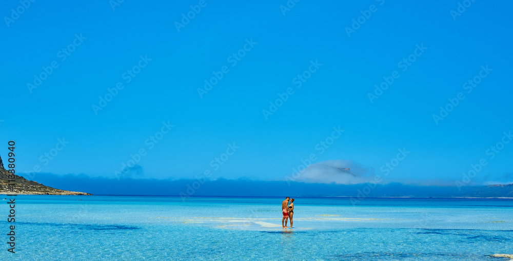 couple standing in the sea near the boat.