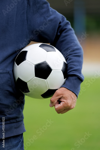 Hand holding soccer ball on stadium © byrdyak