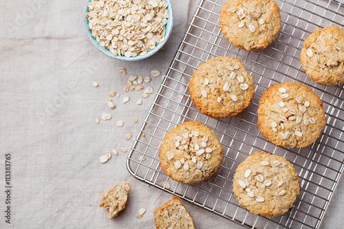 Healthy vegan oat muffins, apple and banana cakes on a cooling rack Grey textile background