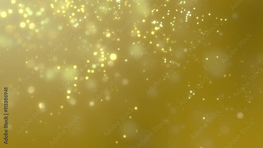Blurred golden dust slowly falling against yellow background Blurred golden dust slowly falling against yellow background