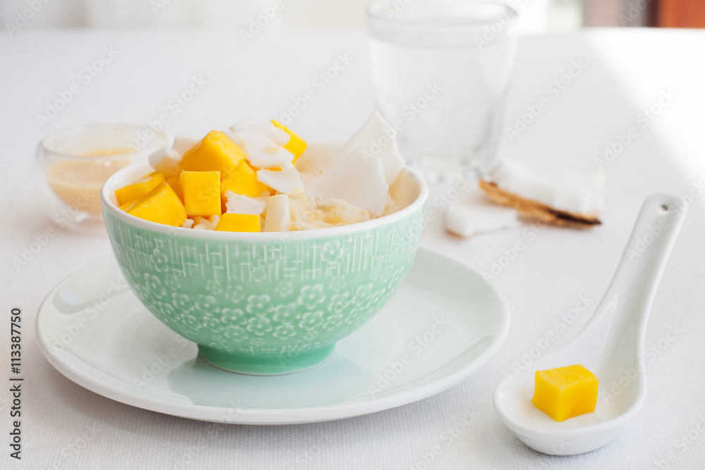 Rice pudding with mango and coconut water in a bowl, khao niaow ma muang White background Rice pudding with mango and coconut water in a bowl, khao niaow ma muang White background