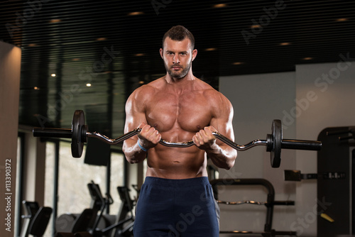 Bodybuilder Performing Biceps Curls With A Barbell