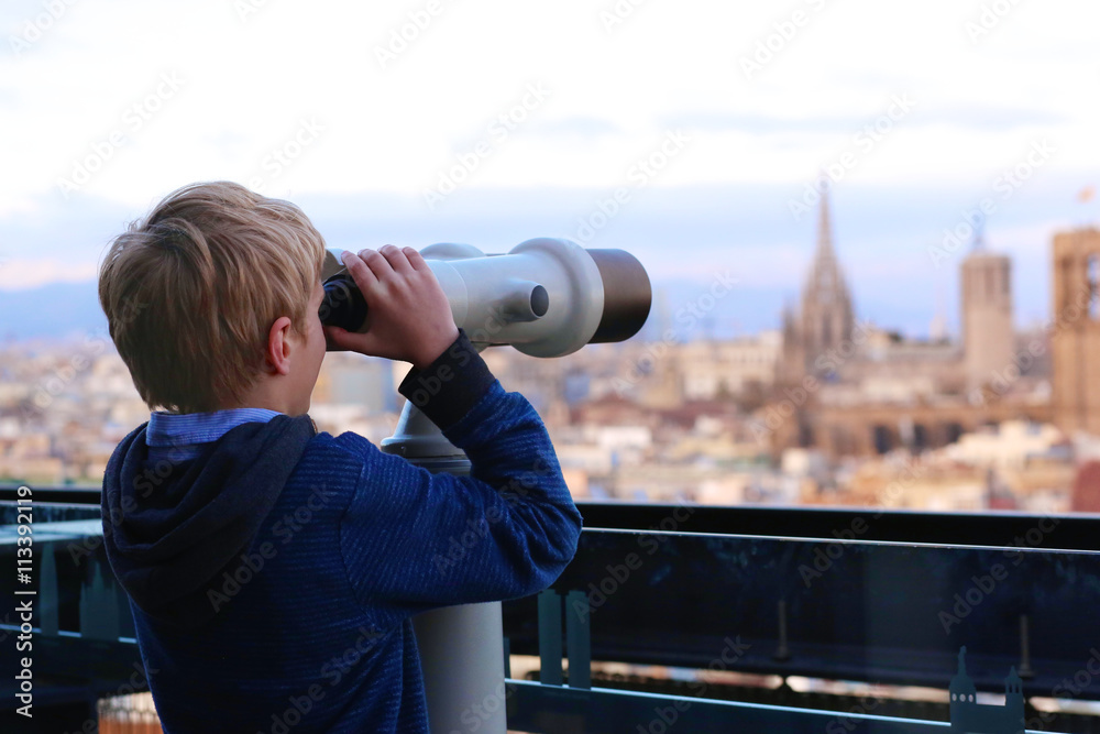 Child enjoying panoramic view of Barcelona, Mediterranean Sea and one of the tallest buildings in the city: Torre Maritima