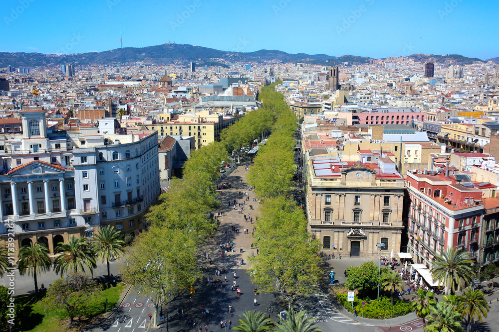 Las Ramblas, main touristic street in Barcelona, Spain. Aerial view from observation platform of Columbus monument. Family destination on summertime.