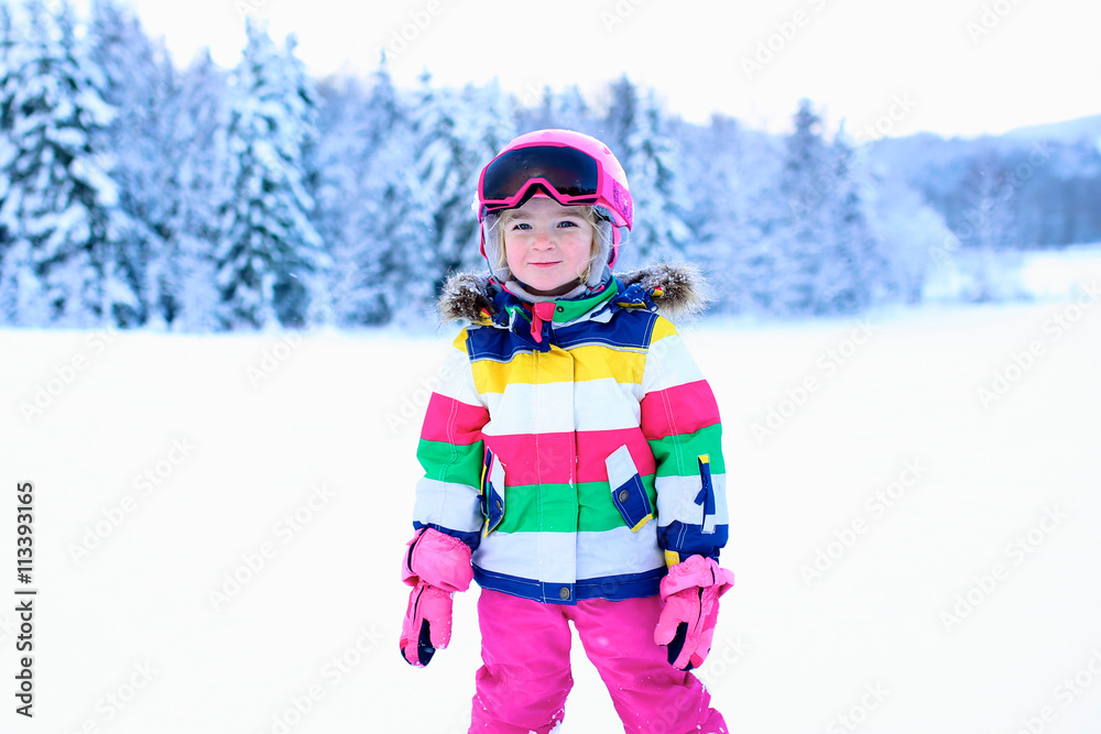 Happy child enjoying vacation in Alpine resort. Little girl skiing in mountains. Active sportive toddler wearing helmet and glasses learning to ski. Winter sport for family. Skier racing in snow. Happy child enjoying vacation in Alpine resort. Little girl skiing in mountains. Active sportive toddler wearing helmet and glasses learning to ski. Winter sport for family. Skier racing in snow.