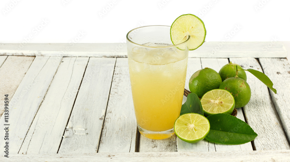 Glass of lime juice with ice on white wood Glass of lime juice with ice on white wood