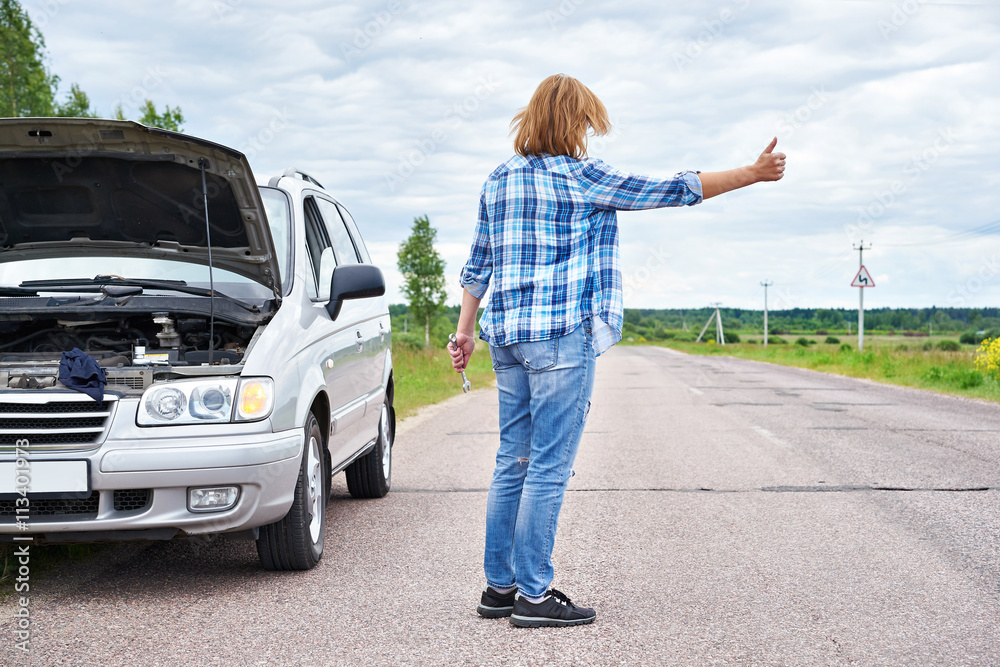 Woman with wrench waiting to help and showing thumbs up Woman with wrench waiting to help and showing thumbs up
