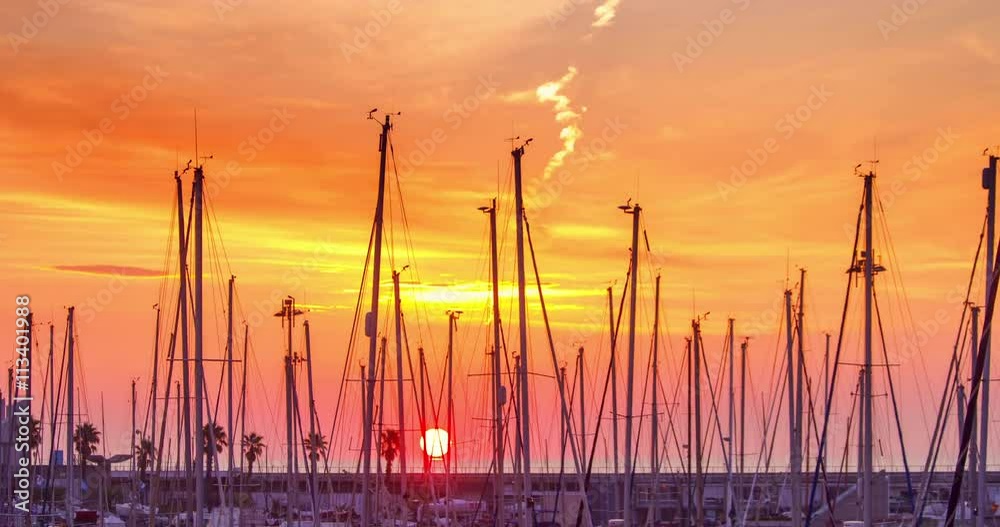 Yacht port at sunrise. Timelapse of yacht marina. Red sky over yacht harbour at morning. Clouds sky. Row of sail masts. Yachts in port at sun rise. Masts silhouettes at red sky in morning sunrise