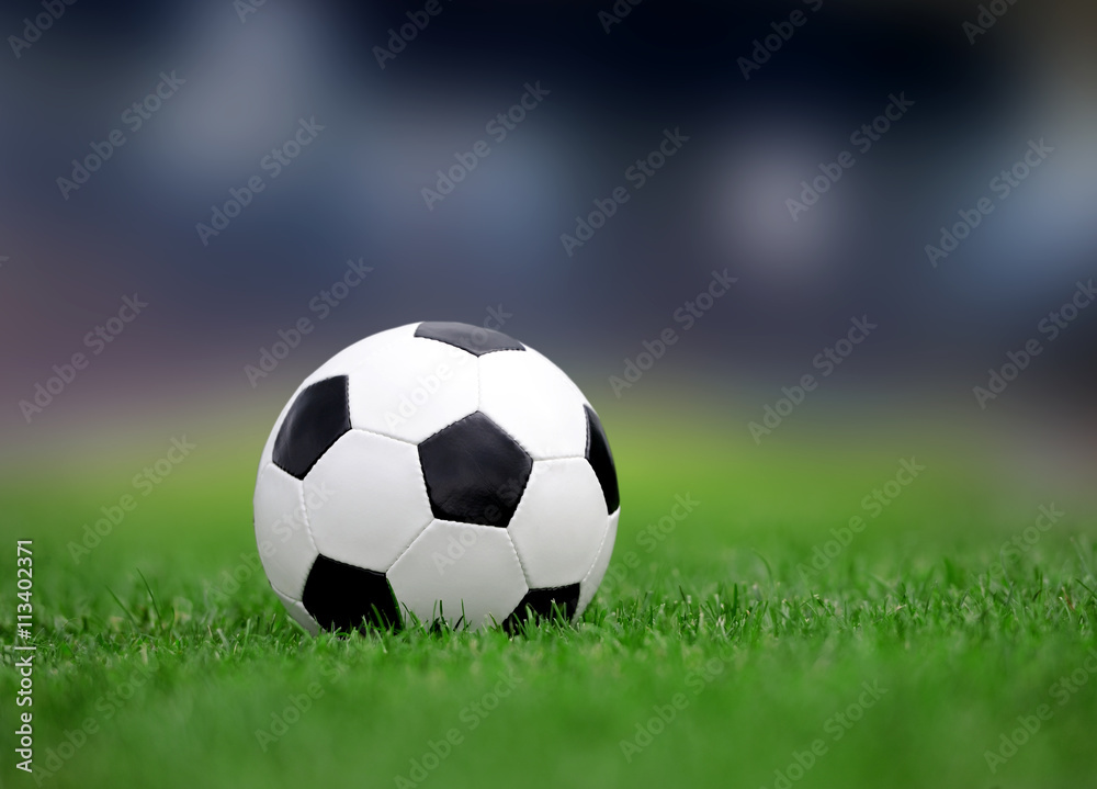 Naklejka premium Soccer ball on green grass
