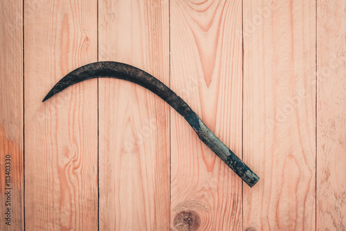 Sickle on wooden floor