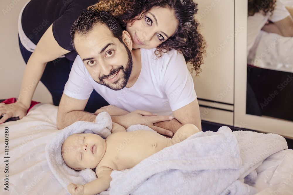 Happy family with newborn baby inside their bedroom