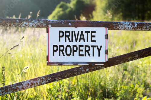 Sign Private Property on a metal gate on the dirt road photo