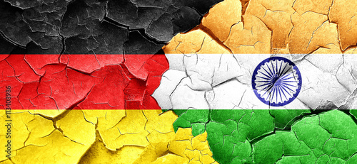 German flag with India flag on a grunge cracked wall