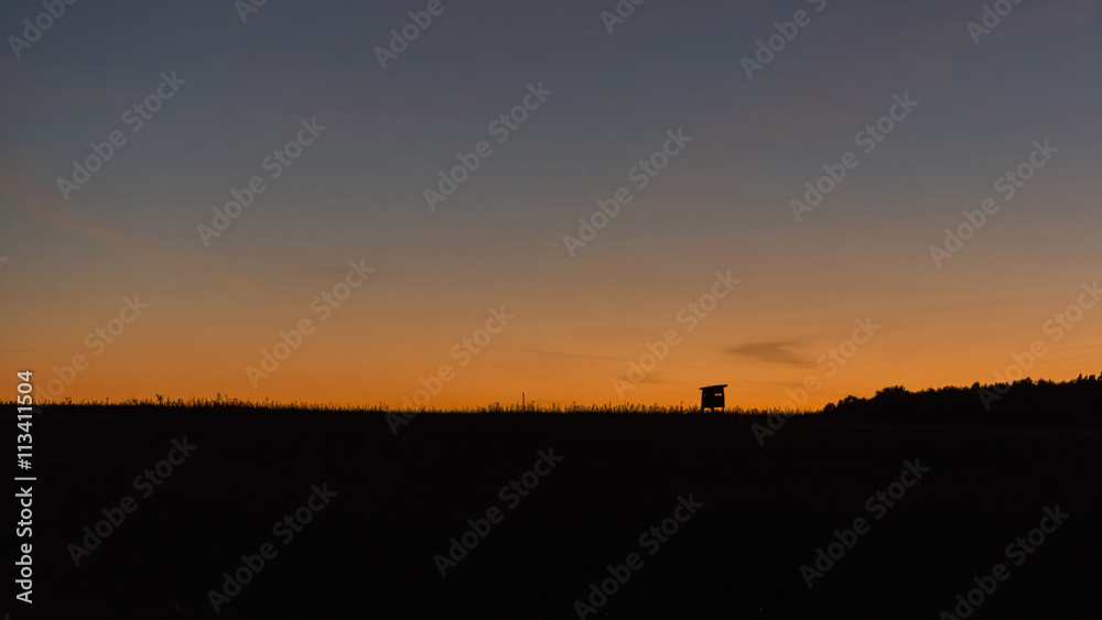 Hunting tower for observing wildlife on the horizon and a colorful sunset