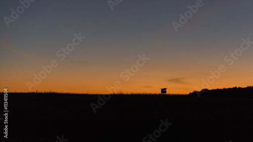 Hunting tower for observing wildlife on the horizon and a colorful sunset