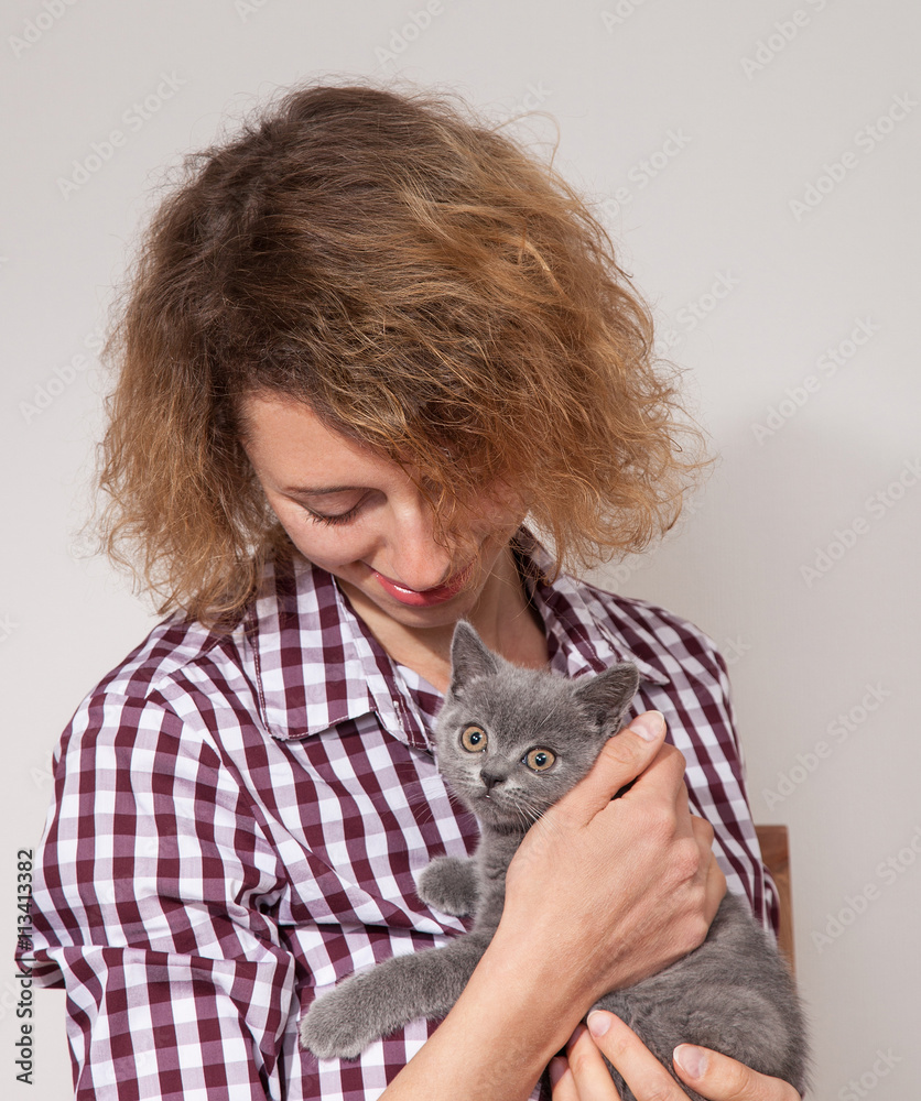 Happy young woman holding little kitten Happy young woman holding little kitten