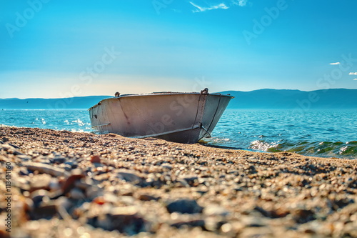 Metal boat on the shore of Lake Baikal. photo