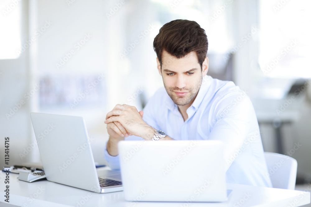Solve the problem. Young businessman working on solving the problem on laptop at office. Solve the problem. Young businessman working on solving the problem on laptop at office.