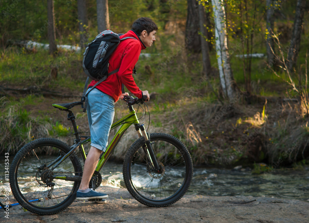 cyclist in the nature against the backdrop of the river cyclist in the nature against the backdrop of the river
