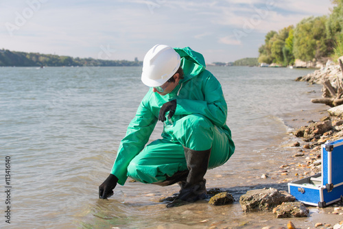 Obraz na plátne Pollution control inspector filling up sample container