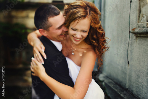Fiance hugs tightly a smiling bride