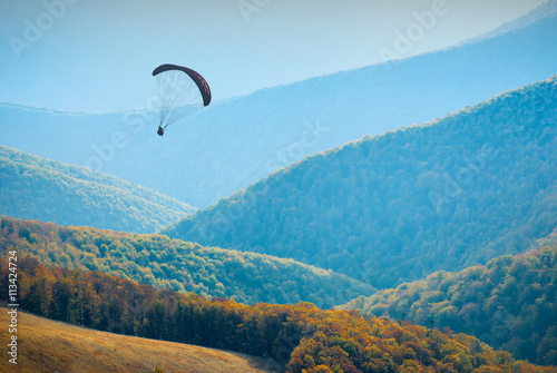 Shadow figure of flying paraglide in a sky