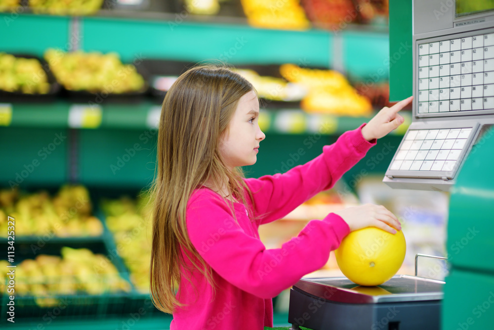 Fototapeta premium Cute little girl shopping in a food store