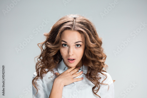 Fotografie The astonished woman on gray background