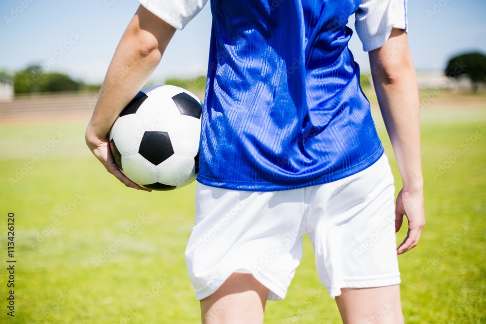 Obraz premium Mid-section of soccer player standing with a ball