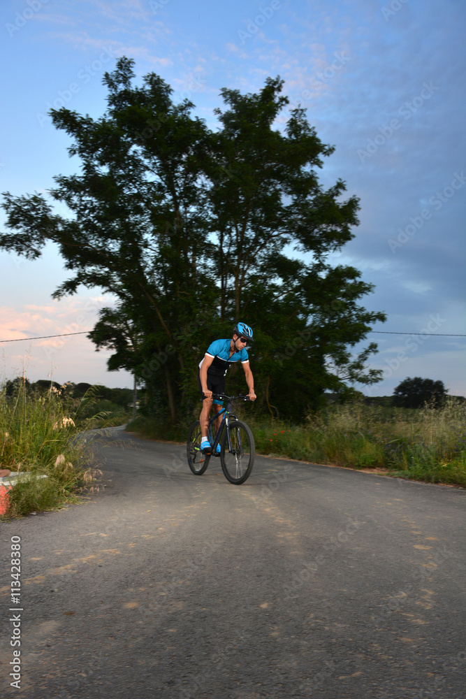 cyclist going mountain bike along a lonely road cyclist going mountain bike along a lonely road