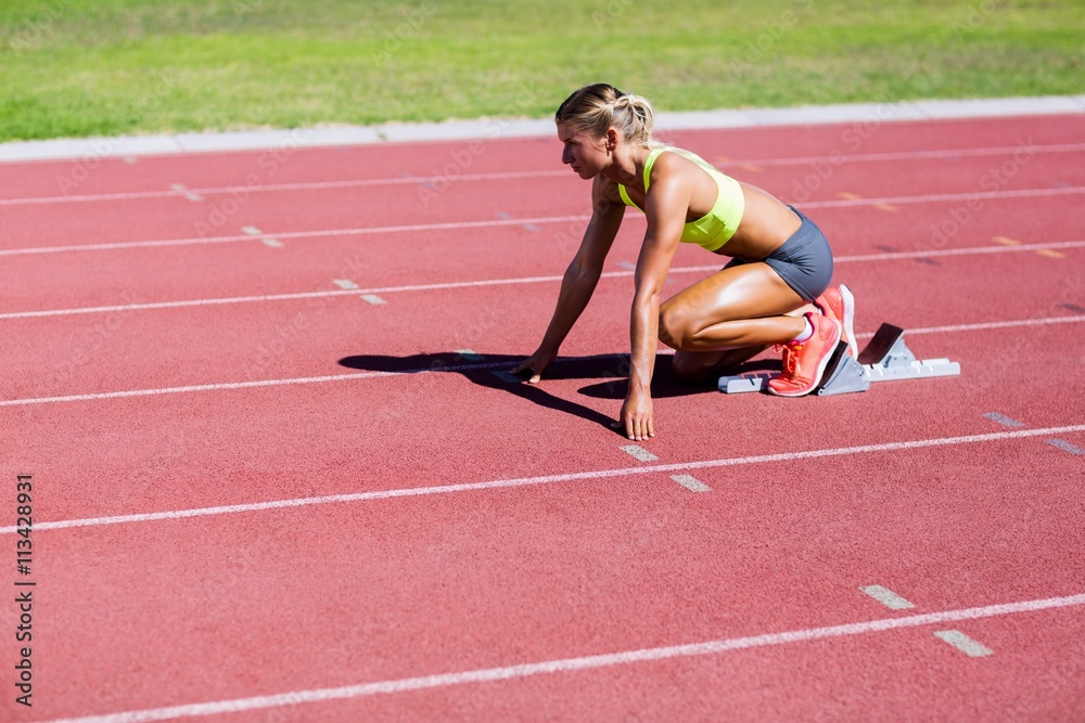 Female athlete ready to run on running track Female athlete ready to run on running track