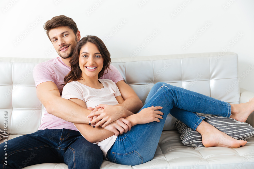 Portrait of a beautiful smiling couple sitting on the sofa Portrait of a beautiful smiling couple sitting on the sofa
