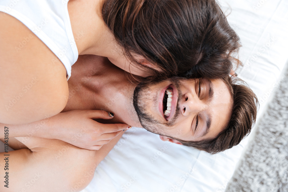 Close-up portrait of a young laughing couple in bed