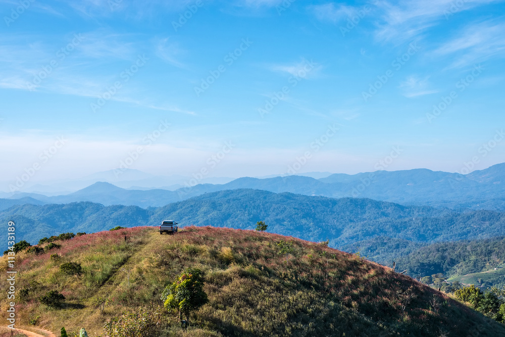 Cars parked on a hill overlooking a beautiful mountain. Cars parked on a hill overlooking a beautiful mountain.