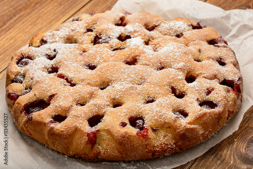 Delicious strawberry pie on wooden background.