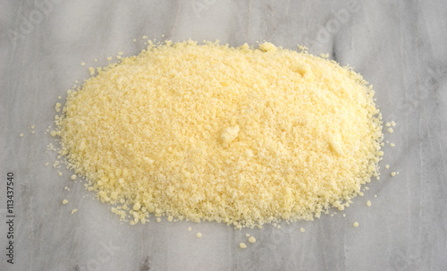 Vászonkép Grated Pecorino Romano cheese on a marble cutting board.