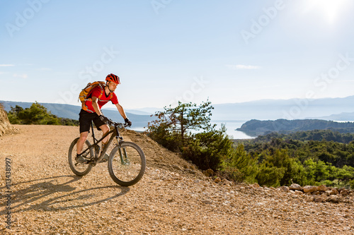 Fototapeta Naklejka Na Ścianę i Meble -  Mountain biker riding on bike at the sea