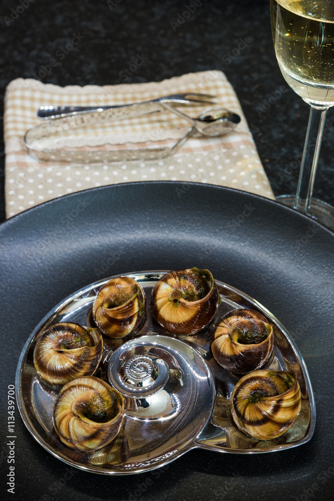 Prepared snails with garlic and parsley in black plate