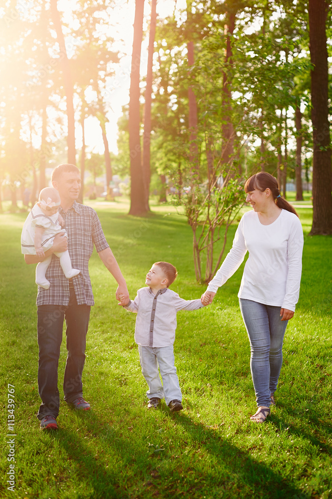 Fototapeta premium happy young family walks in the summer park