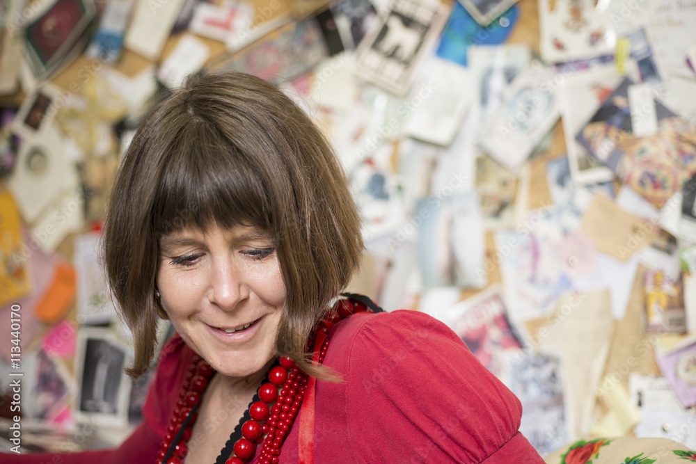 Lady in Red Blouse and Necklaces Staring Below and Smiling Lady in Red Blouse and Necklaces Staring Below and Smiling
