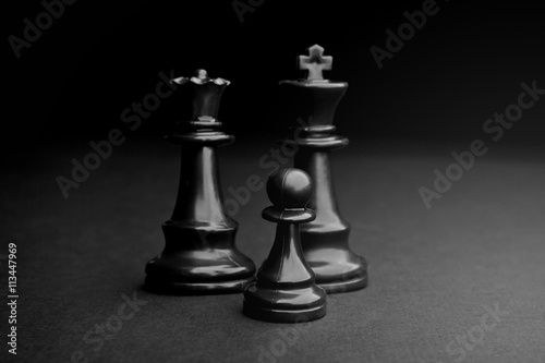 Chess. Black Pawn, King and Queen on black background.
