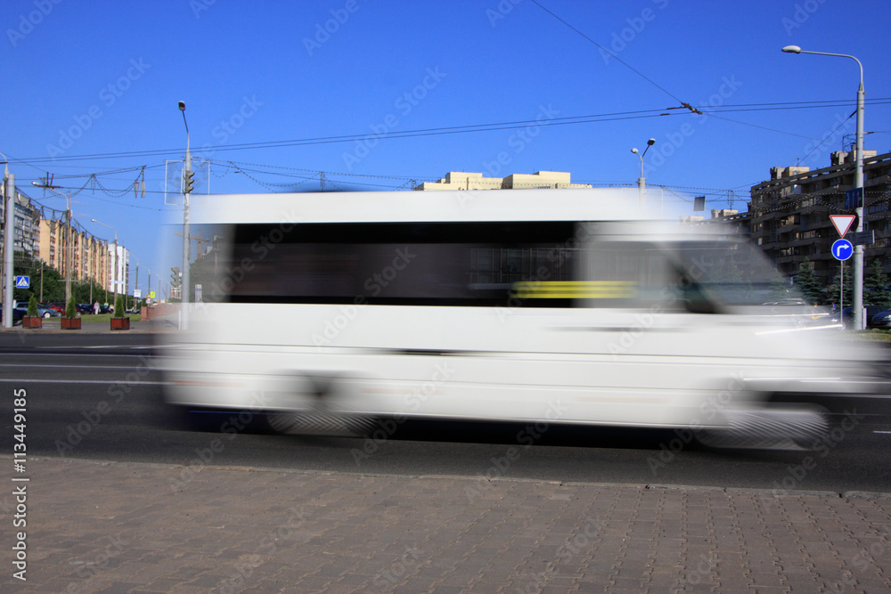 Motion white blurred minibus\Motion blurred white minibus on the street in the afternoon